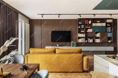 노란색 소파와 Tv와 책장이 있는 라멜라 벽이 있는 창의적이고 현대적인 빈티지 거실 인테리어 디자인 | 프리미엄 사진