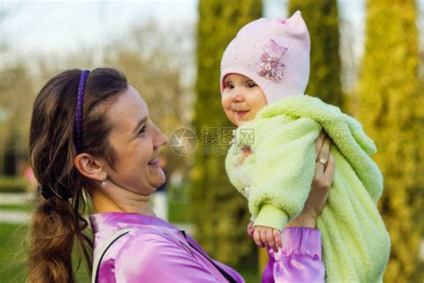 一位年轻的母亲把她快乐的小女儿抱在怀里高清图片下载-正版图片506475992-摄图网
