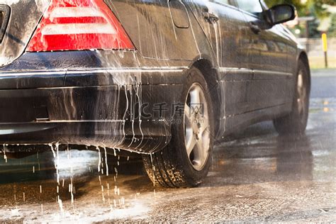 年轻人在洗车场用水洗一辆白色汽车高清图片下载-正版图片504362272-摄图网