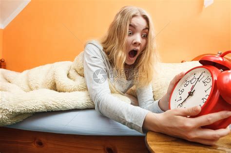 惊慌的女人早上醒过来闹钟响起年轻女孩躺在床上高清图片下载-正版图片304098576-摄图网
