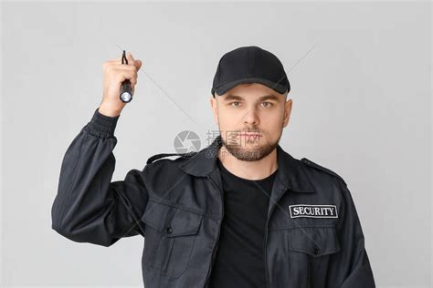 灰色背景中带手电筒的男保安高清图片下载-正版图片503872064-摄图网