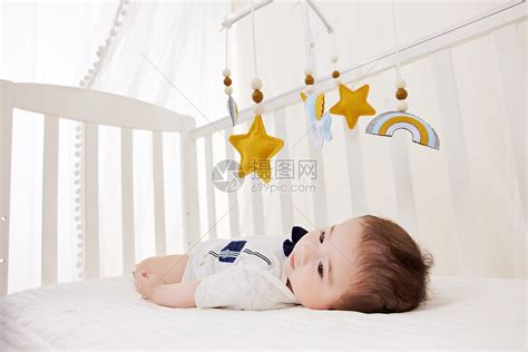 初生宝宝在婴儿床上玩摇铃高清图片下载-正版图片502506378-摄图网