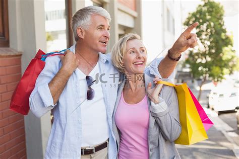 幸福的成年夫妇带着他们购物的东西走路高清摄影大图-千库网