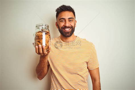 年轻的印度男子拿着一罐饼干高清图片下载-正版图片504086772-摄图网