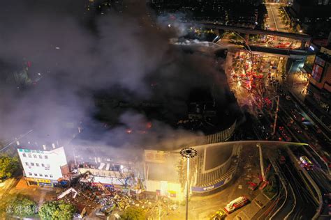 南京金盛百货商场起火前后画面对比：部分建筑骨架露出，多个楼层受损严重