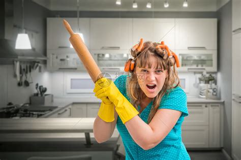 疯狂的主妇穿着围裙在火上煮西兰花，背景是厨房内部。高清摄影大图-千库网
