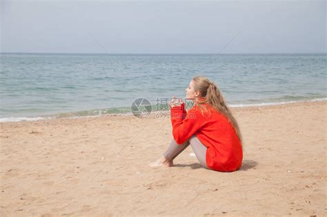 一个女人坐在荒凉的沙滩上高清图片下载-正版图片505706147-摄图网