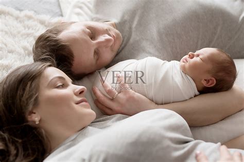 刚出生的婴儿在爸爸妈妈的怀里躺在床上。明信片母亲节和父亲节。儿童保护的一天。世界上幸福的一天。微笑的孩子。快乐的亲子关系照片摄影图片_ID ...