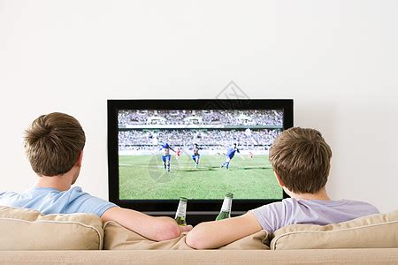 兴奋的父亲和少年子在电视上看比赛在家里拿高清图片下载-正版图片505620875-摄图网