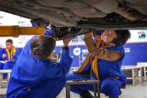 英俊的汽车修理工帮助女顾客在当代汽车修理店从各种优质轮高清图片下载-正版图片503613929-摄图网