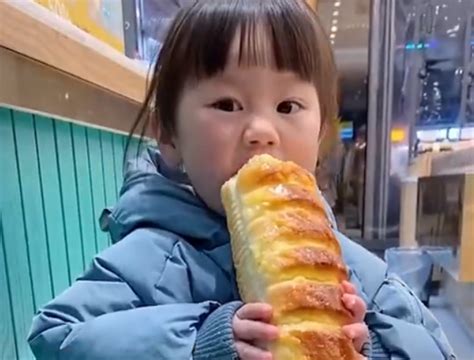 2岁萌娃在橱窗边偷“啃面包”引争议，网友：经不住食物的诱惑！__凤凰网