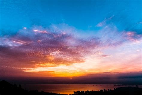 自然风景素材设计日落时分天边的云彩一片殷红夕阳的余晖散落在水面上反射出昏黄的光