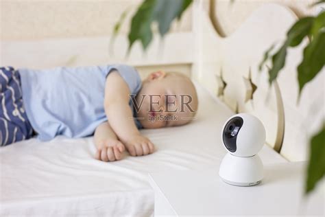 可爱的小男孩睡在家里的床上和婴儿监视器摄像头。照片摄影图片_ID:424614038-Veer图库
