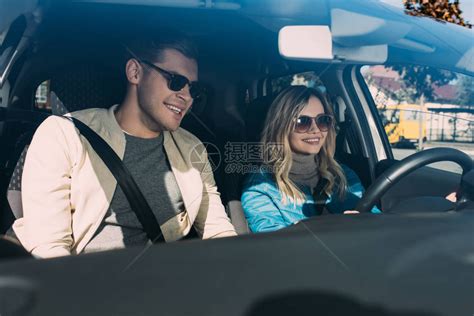 微笑着的年轻女驾驶汽车与男朋友相近的高清图片下载-正版图片502919957-摄图网