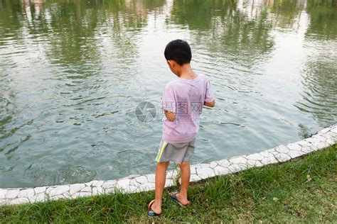 生活在池塘中喂鱼的泰国男孩人们喂养高清图片下载-正版图片307648302-摄图网