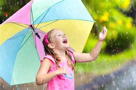 孩子在雨中玩耍。孩子们带着雨伞在外面下大雨.第一次春雨中被抓住的小女孩。秋天的雨天使孩子们在户外玩得很开心.在热带风暴中奔跑的儿童.高清摄影大 ...