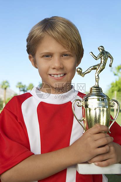年轻男孩骄傲地拿着足球奖杯的肖像高清图片下载-正版图片321865784-摄图网