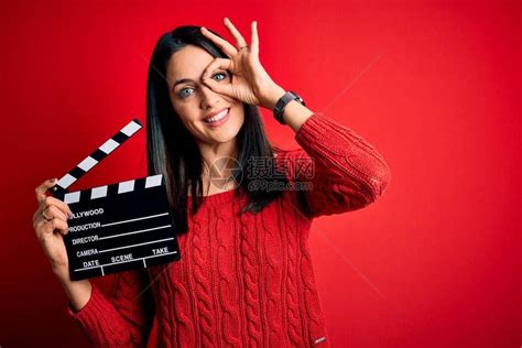 蓝眼睛的年轻导演女导演在红色背景上拿着隔板高清图片下载-正版图片503675433-摄图网