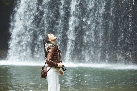 站在岩石下享受瀑布的女人高清图片下载-正版图片502071619-摄图网