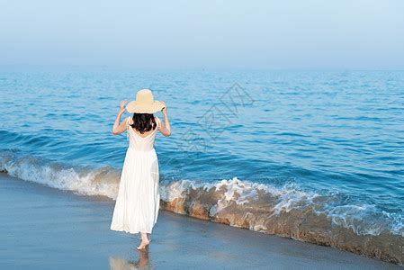 海岛旅行傍晚海滩玩耍的女孩户外沙滩站立摆拍侧面摄影图配图高清摄影大图-千库网