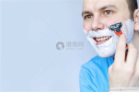 留着胡子的英俊大胡子男使用电动修剪器修剪鼻子上的头发高清图片下载-正版图片506226253-摄图网