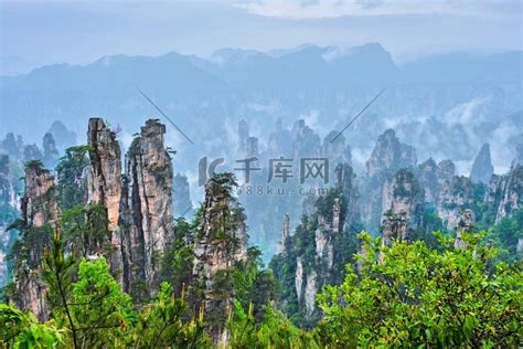 中国著名旅游胜地-中国湖南武陵源雾云中的张家界石柱悬崖山。山峦风景高清摄影大图-千库网
