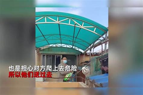 封控第10天上海一居民断粮，男子爬上屋顶给邻居送去一包粮食_封控第_屋顶_男子