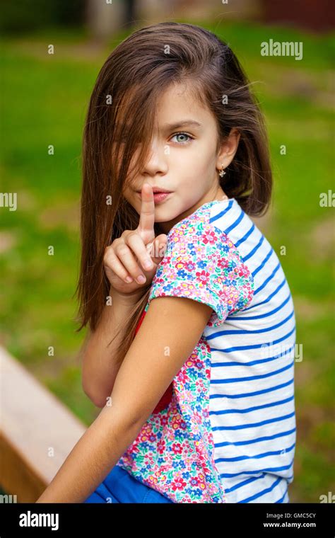 Young beautiful Little girl has put forefinger to lips as sign of ...