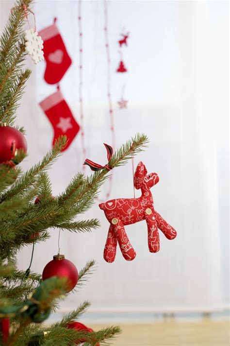 圣诞装饰图片-红色背景下圣诞树上挂着的圣诞装饰品素材-高清图片-摄影照片-寻图免费打包下载