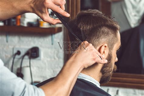 发型和发型年轻帅哥手里拿着理发师的专用剪子工具就在蓝色男人用剪刀织纹或变薄剪刀高清图片下载-正版图片307184748-摄图网
