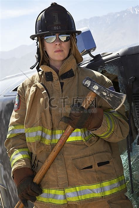 快乐名女消防员站在反对救火车高清摄影大图-千库网