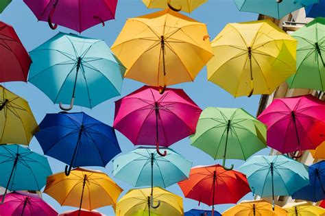 五颜六色的雨伞串接在一起点缀着街道和湛蓝的天空