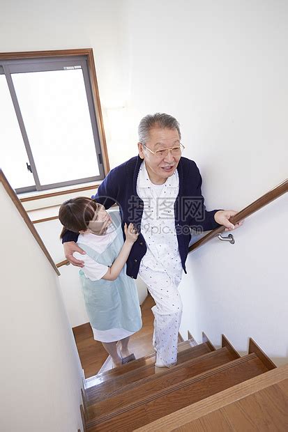 护工搀扶行动不便的老人上楼梯高清图片下载-正版图片502005203-摄图网