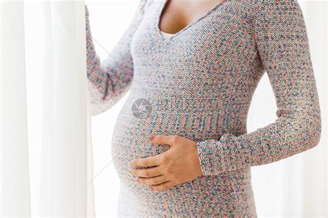 怀孕,人母亲的密切孕妇大腹便便家里下雪抱着大肚子的孕妇高清图片下载-正版图片300432518-摄图网