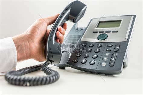 商人拿着电话听筒准备在固定电话上打电话的特写镜头客户服务或电高清图片下载-正版图片502594115-摄图网