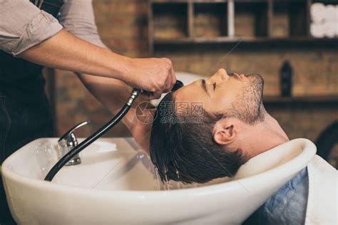 头发廊概念男理师拿着水淋浴的男子理发师轻清洗女顾客的头发型医疗造高清图片下载-正版图片308029919-摄图网