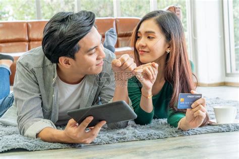 年轻夫妻使用信用卡在家中网购高清图片下载-正版图片302585436-摄图网