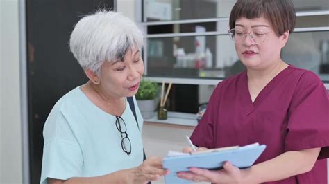亚裔华裔女护士在诊所向她的资深女病人解释体检报告视频素材_ID:VCG42N1357123465-VCG.COM