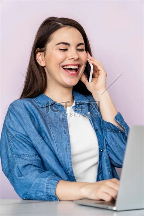 肖像快乐的女人用笔记本电脑打电话牛仔衣夹克高清摄影大图-千库网