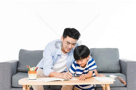 沙发上父亲辅导孩子写作业高清图片下载-正版图片500957525-摄图网