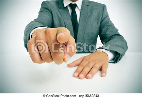 Man in suit pointing the finger. Man wearing a suit sitting in a table ...