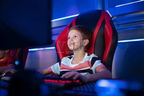集中精力在个人电脑上玩网络游戏的年轻玩家。照片摄影图片_ID:421683089-Veer图库