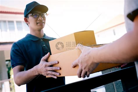 货物工作人员把装有包裹的纸板箱交给收货人手高清图片下载-正版图片305637033-摄图网