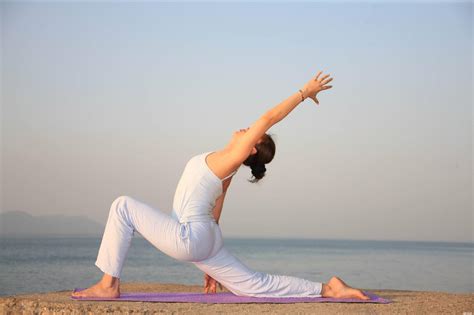 清晨穿着白裤子蓝背心在阳台上做瑜伽的年轻女孩高清图片下载-正版图片500129155-摄图网