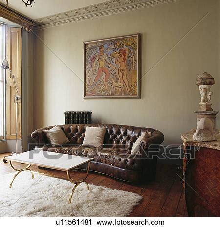 Large picture above brown leather Chesterfield sofa in living room with ...